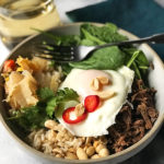 bowls of beef, spinach, rice or veggies, kimchi, peanuts, cilantro and an over easy egg.