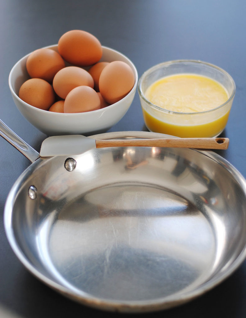metal saute pan with fresh eggs and butter ready to learn to scramble