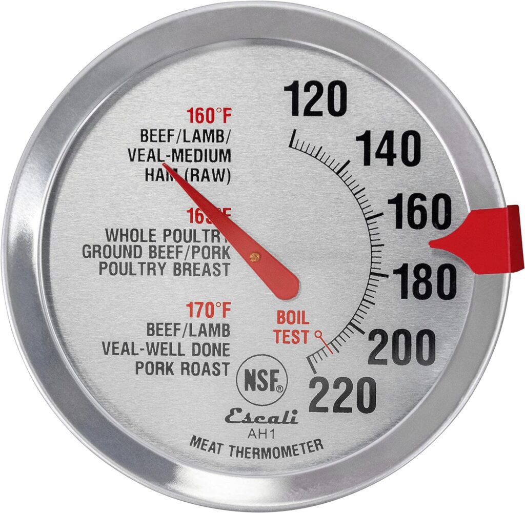 face of an oven thermometer with degrees and recommended cooking temperatures with red arrow and silver metal edging