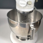 kitchen aid mixer in white with silver bowl on marble surface