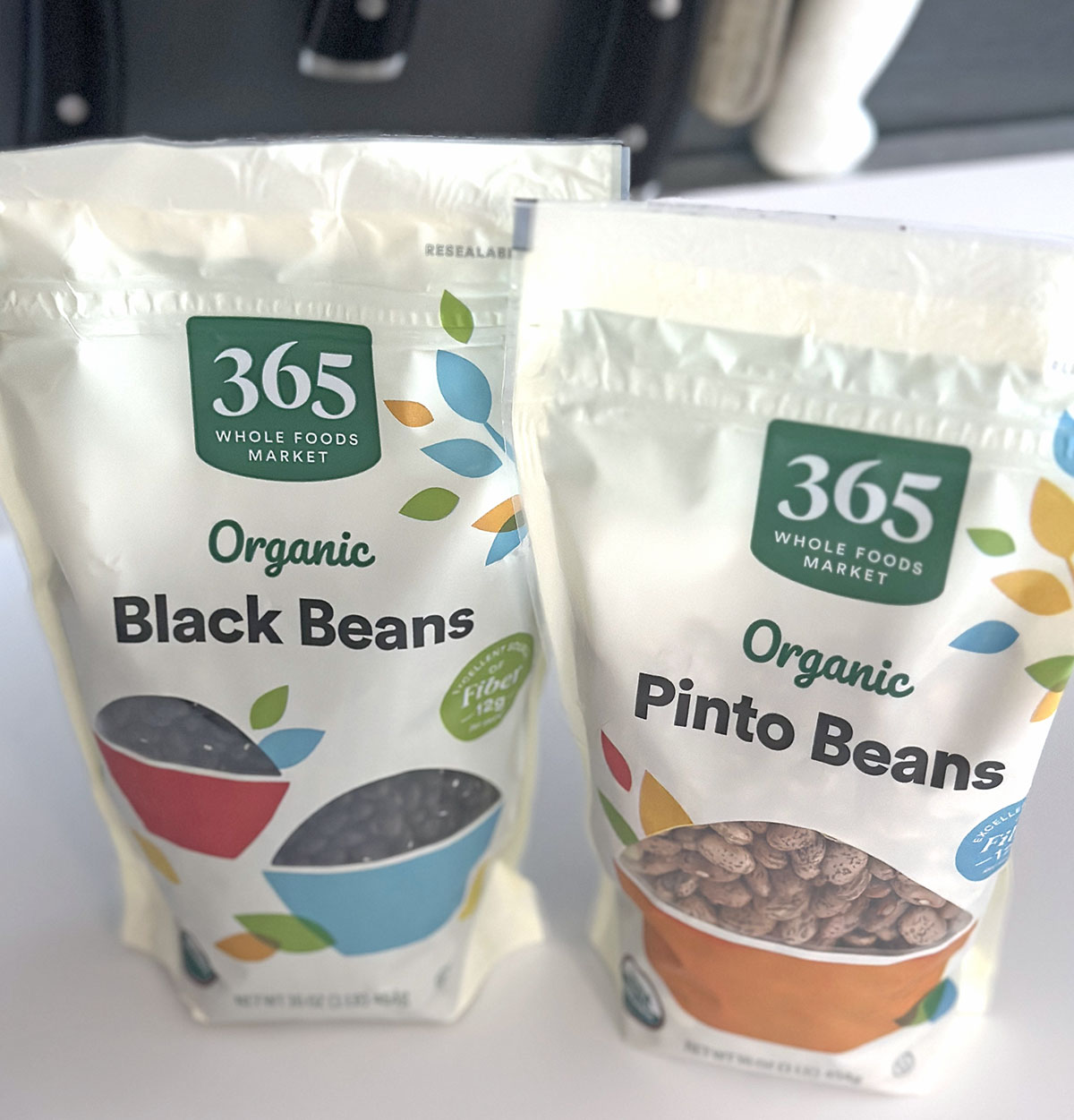 a bag of organic dried black beans next to a bag of organic dried pinto beans