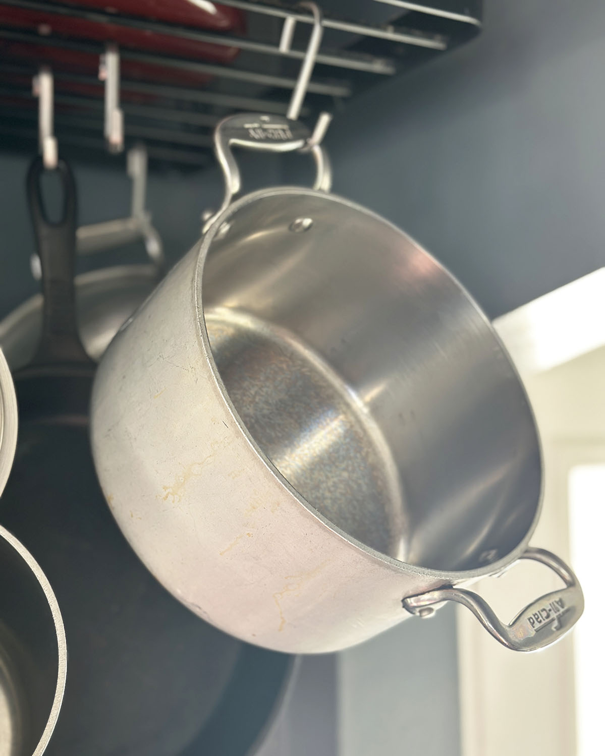 a medium sauce pan or stock pot handing from a pot rack