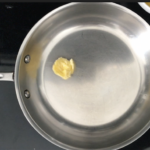 Ghee melting in a stainless steel pan before adding eggs
