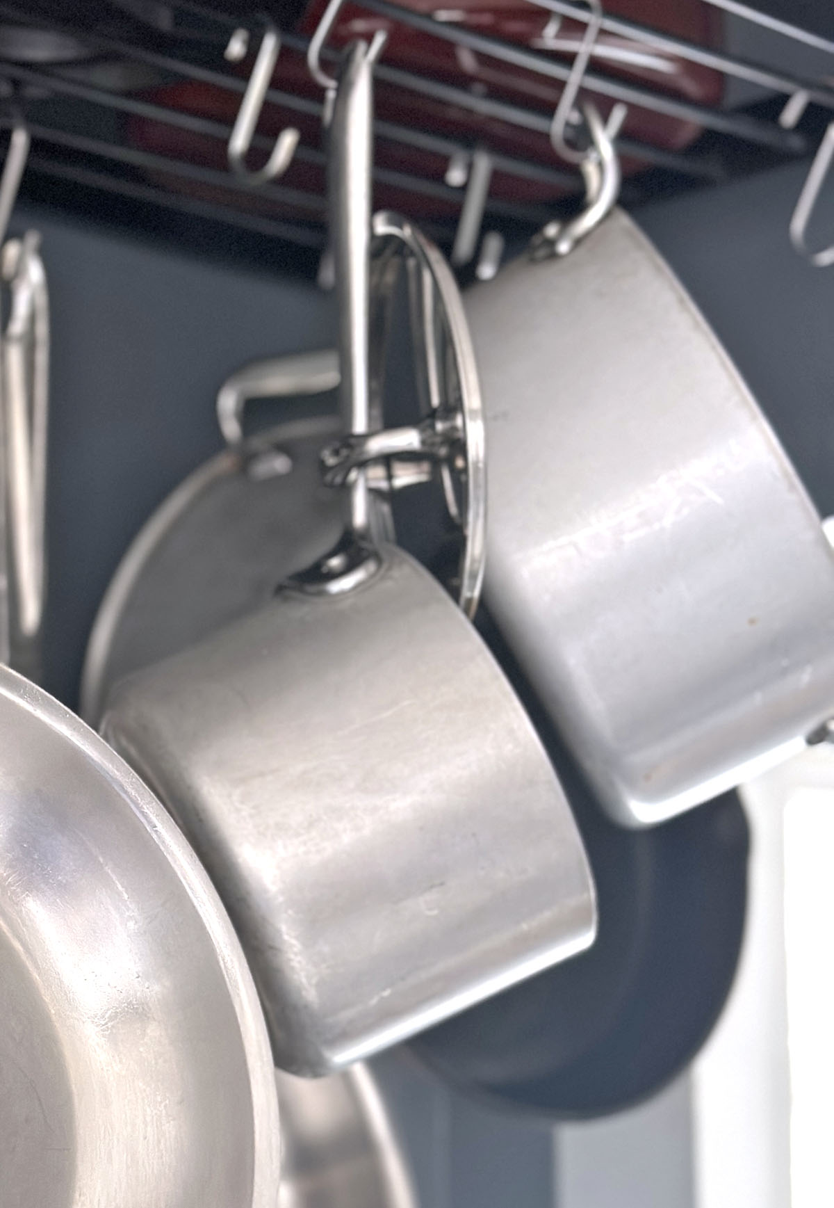 Stainless steel pots and pans on a kitchen rack