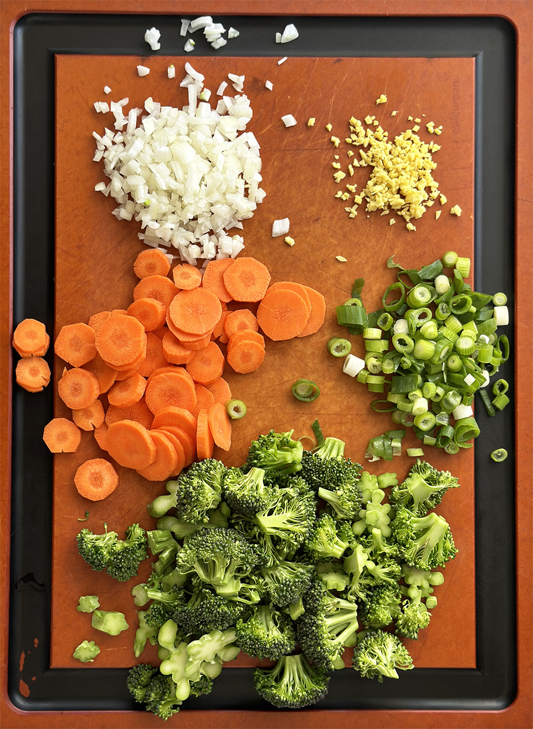 cutting board with edge for catching drips and chopped vegetables in piles