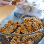 Hands shaping oat and nut butter energy bites from a mixing bowl with oats and chocolate chips – step-by-step protein snack recipe.